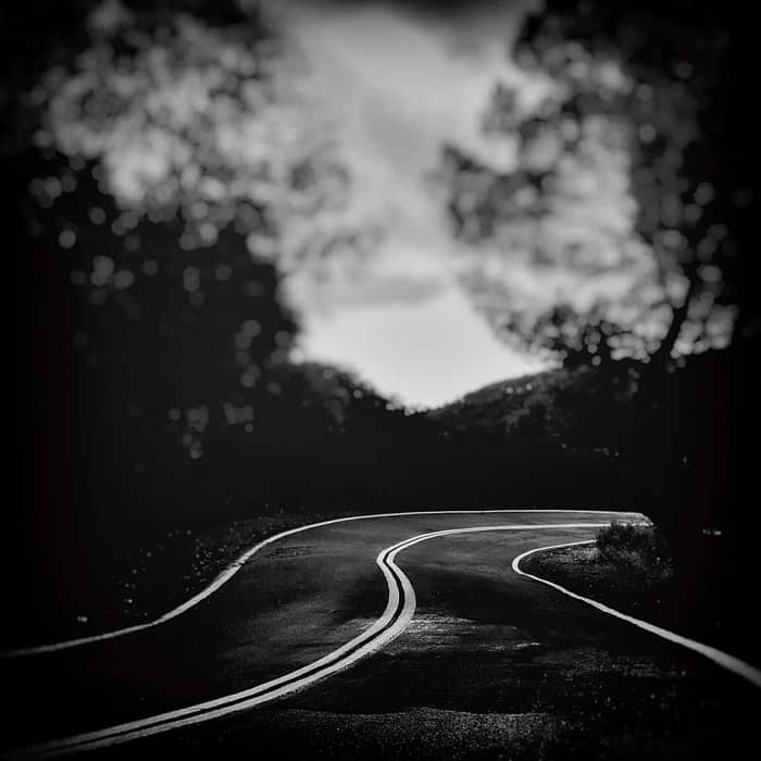 moody black and white image of a road